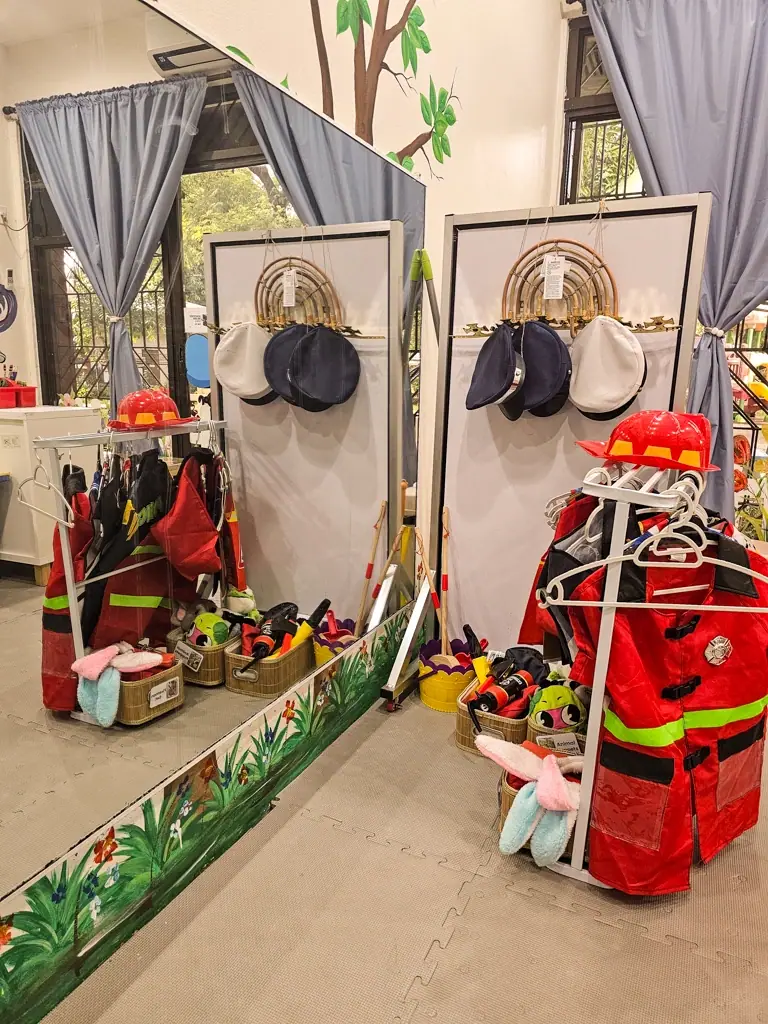 Dress-up corner with firefighter costumes and hats
