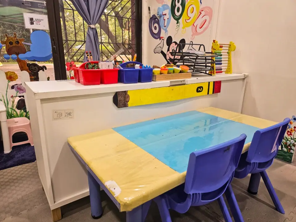 Sensory table by the window with bins of toys