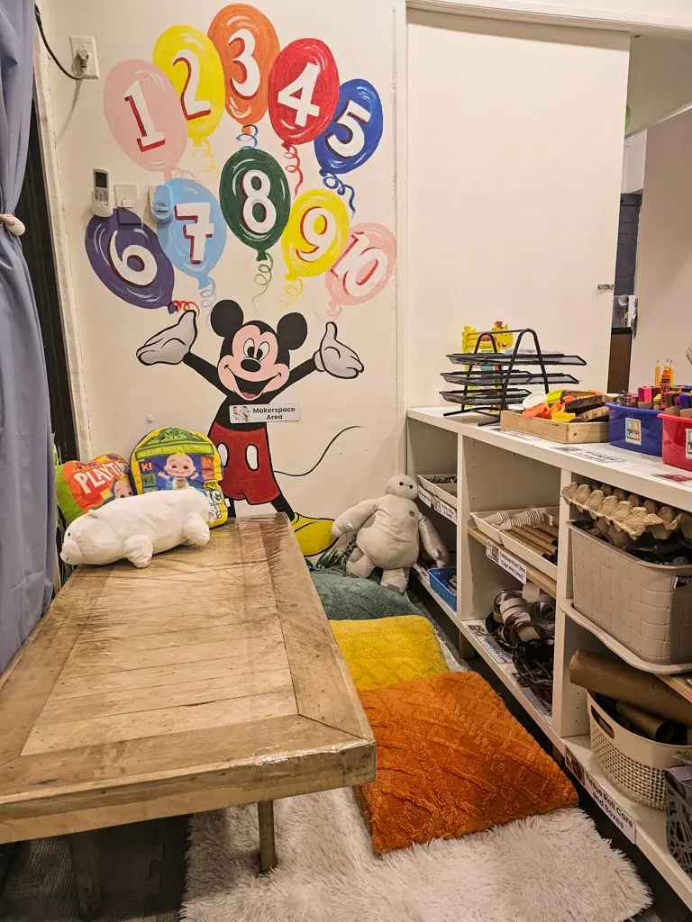 Reading nook with a soft rug and a cartoon mural