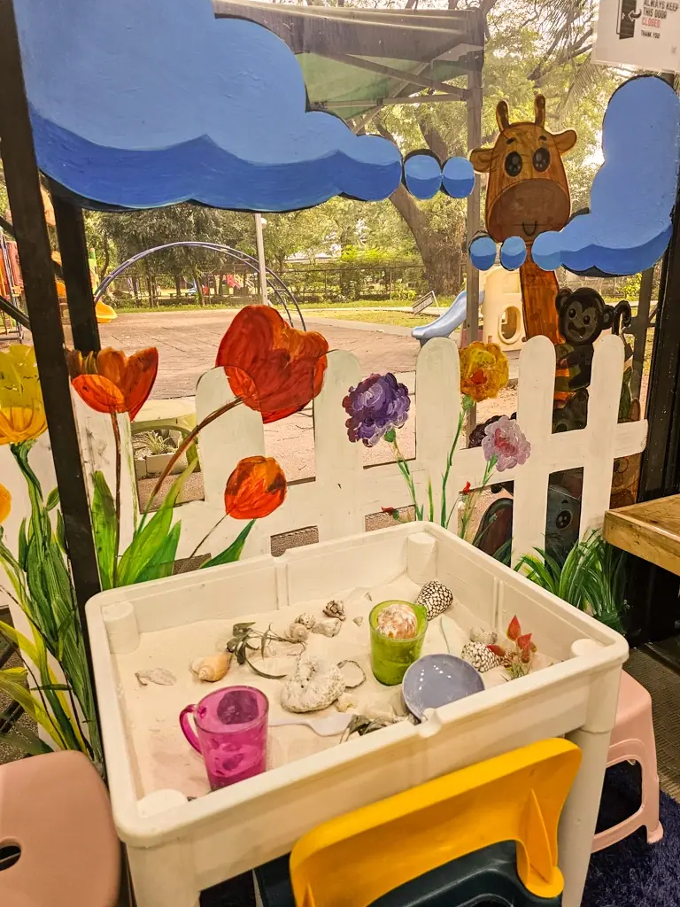 Garden-themed sensory bin with shells and flowers