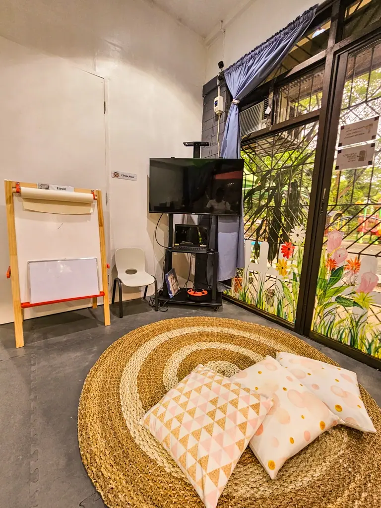 Quiet corner with a woven rug, cushions and an easel