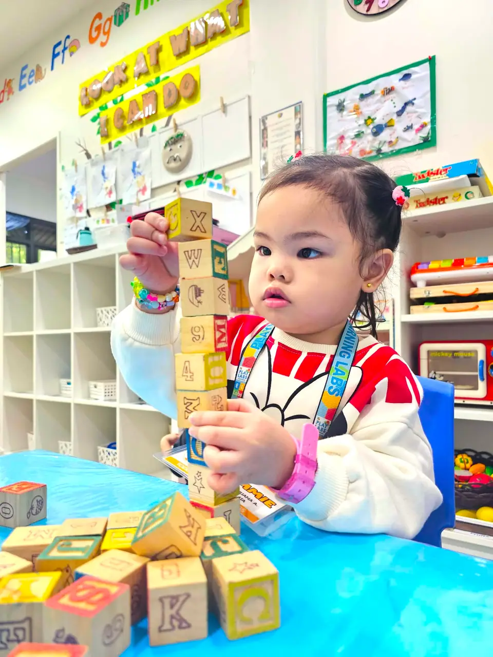 Child exploring letter blocks at Enriched Learning Labs